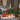 Christmas flower arrangements with white blooms, evergreen garlands, red berries, pine cones and candles on a dining table.