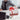 Man holding out a gift box with a red ribbon across an office desk, illustrating a farewell gift for a manager.