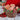Woven festive gift basket filled with wrapped presents, greenery and red berries.
